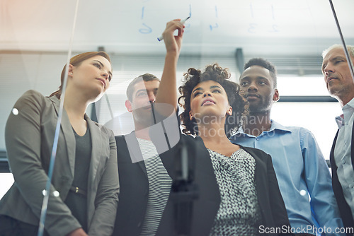 Image of Woman, writing and glass with business people in teamwork for strategy, planning and collaboration in office. Female leader, pen and brainstorming with group, ideas and notes for goal with diversity