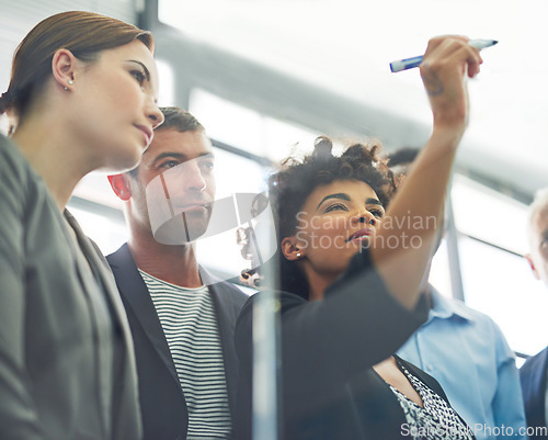 Image of Woman, writing and glass with business people in group for strategy, planning and collaboration in office. Female leader, pen and brainstorming with teamwork, ideas and notes for goal with diversity