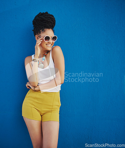 Image of Sunglasses, fashion and portrait of woman on blue background, wall and summer streetwear, trendy clothes or shades mockup. Girl, happy and excited model with cool style, vision and urban mock up