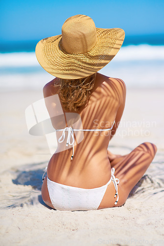 Image of Travel, holiday and back of woman on beach for adventure, paradise and vacation in Mauritius. Tropical mockup, island and female person relax in bikini and hat on sand for tourism, freedom or getaway