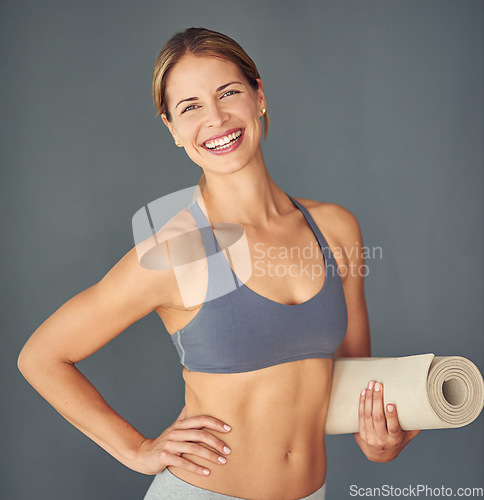 Image of Happy woman, fitness and portrait for yoga exercise, zen workout or healthy body against a grey studio background. Female person or yogi with smile and mat for spiritual wellness and mental health