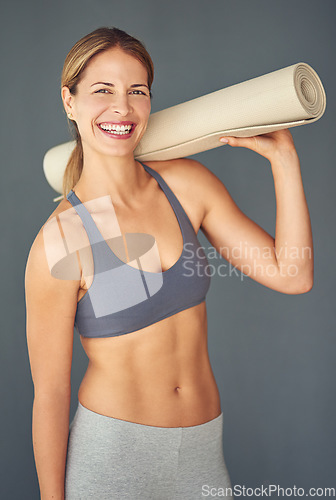 Image of Happy woman, fitness and portrait smile with yoga mat for workout exercise or healthy body against a grey studio background. Female person or yogi smiling for spiritual wellness, zen or mental health