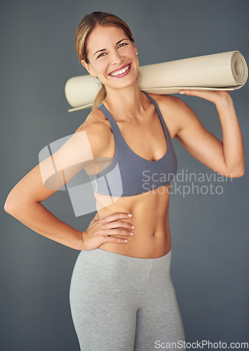 Image of Happy woman, portrait and yoga mat for zen workout, exercise or healthy body against a grey studio background. Female person or yogi with smile for spiritual wellness, fitness and mental health