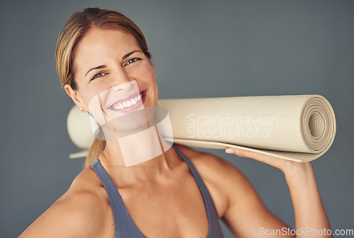 Image of Happy woman, face and portrait smile with yoga mat for fitness, zen workout or exercise against a grey studio background. Female person or yogi smiling for healthy wellness, mental health or pilates