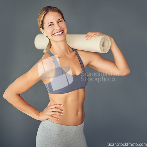 Image of Happy woman, portrait and fitness body with yoga mat for zen workout or exercise against a grey studio background. Female person or yogi with smile for healthy wellness, mental health and pilates