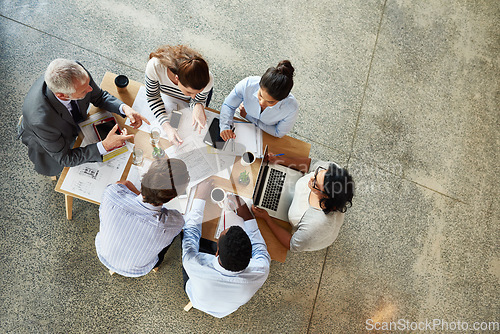 Image of Top view, staff and group brainstorming, teamwork or collaboration with ideas, discussion or planning. Business people, men or women in a modern office, paperwork or laptop with partnership or growth