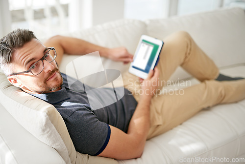 Image of Man, portrait and tablet on living room sofa, reading and social media for video, game or movies in home. Mature guy, digital touchscreen and lounge couch for internet blog, news and web app in house