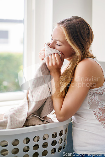 Image of Woman, housekeeping and clean laundry smell or cleaning clothes, fabric or blanket with fragrance and happy home routine. Person, fresh linen and smelling scent of detergent product or soft clothing