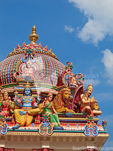 Image of Hindu temple, Sri Mariamman and blue sky of history, culture and religion architecture in Singapore. Background, indian faith and worship, prayer or spiritual sign of building design, art and roof