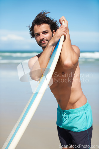 Image of Portrait, surf and a man in the ocean at the beach for surfing while on summer holiday or vacation. Surfboard, body and windy with a young male surfer shirtless outdoor by the sea for a sports hobby