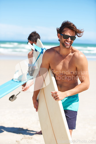 Image of Travel, summer and surfing friends on the beach together together for vacation or holiday trip overseas. Surf, ocean or fun with a young man surfer in sunglasses and friend bonding outdoor by the sea