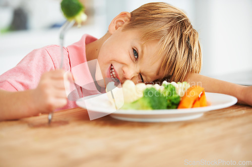 Image of Food, health and child eating vegetables for a healthy, growth and wellness diet at his home. Nutrition, dinner and boy kid laying on a dining table with produce lunch, snack or meal at his house.