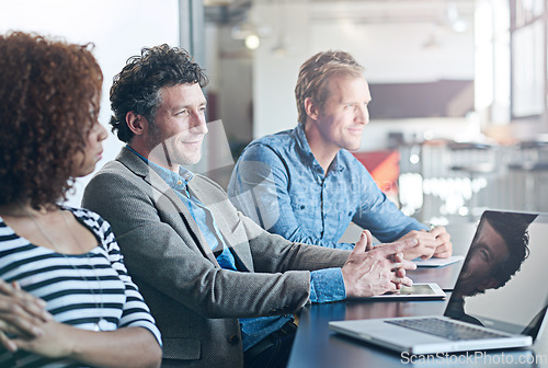 Image of Business, meeting and listen or focus at office for entrepreneur with laptop at startup. Employees, together and brainstorming for a project with smile or watching in a creative company with tech.