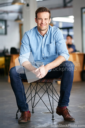 Image of Happy, confidence and portrait of a man in a office sitting on a chair with success, vision and ambition. Happiness, smile and professional male entrepreneur with startup business in modern workplace