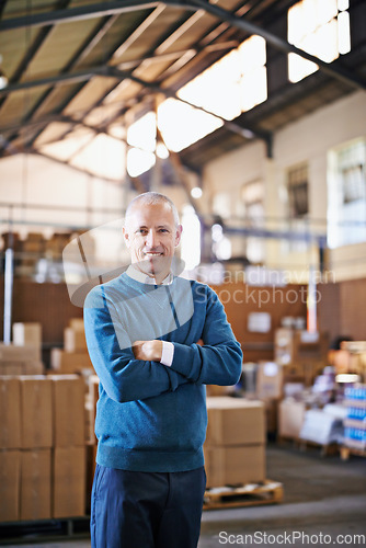 Image of Arms crossed, smile and portrait of man in warehouse for cargo, storage and shipping. Distribution, ecommerce and logistics with employee in factory plant for supply chain, package and wholesale