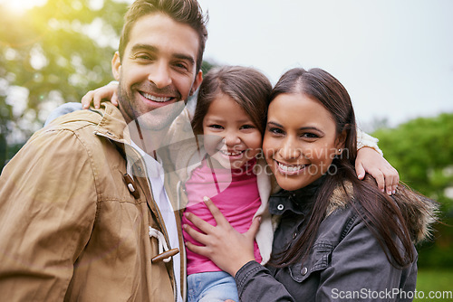 Image of Family, happy hug and park portrait with a mom, dad and girl together with happiness and smile. Outdoor, face and vacation of a mother, father and young kid with bonding, parent love and child care