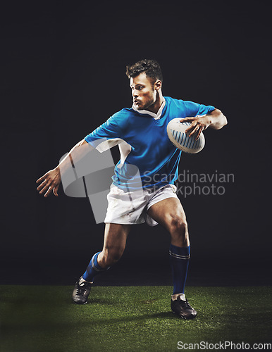 Image of Rugby, black background and man athlete running in dark studio while training, wellness and fitness sports. Exercise, workout and professional career of sport male person or player on grass