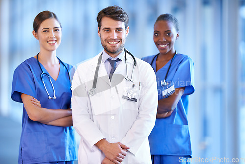 Image of Medical, collaboration and portrait of doctor with nurses standing in a corridor of the hospital. Confidence, diversity and team of happy professional healthcare workers with smile in medicare clinic