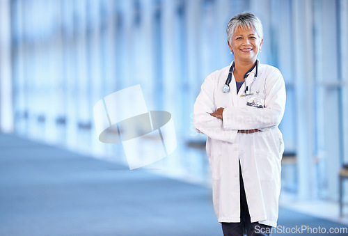 Image of Portrait, healthcare and arms crossed with a senior doctor standing in a hospital corridor for research or insurance. Medical, trust and technology with a woman medicine professional in a clinic