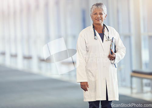 Image of Portrait, healthcare and documents with a senior doctor standing in a hospital corridor for insurance or treatment. Medical, trust and paperwork with a woman medicine professional in a health clinic