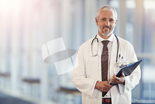 Image of Portrait, healthcare and documents with a senior doctor standing in a hospital corridor for insurance or treatment. Medical, trust or clipboard with a man medicine professional in a clinic for health