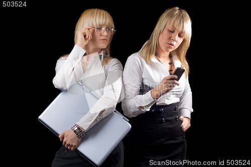 Image of Two young businesswomen with laptop and phone. Isolated
