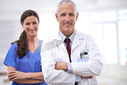 Image of Doctors, man and woman in portrait with arms crossed for health, wellness and team in hospital. Mature healthcare expert, nurse and professional with medical knowledge, solidarity and smile in clinic