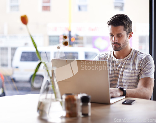 Image of Coffee shop, working and serious man with laptop and code work in a cafe. Tech, email and male freelancer customer at a restaurant table with online pc and computer writing with focus on web coding