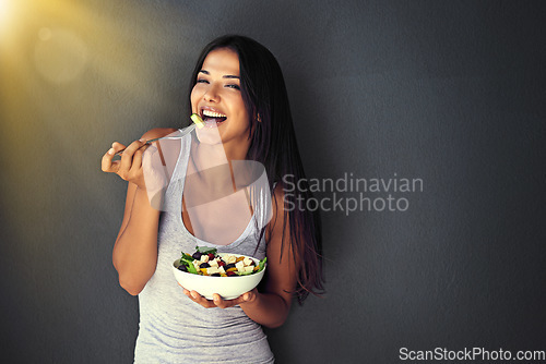Image of Happy woman is eating a salad, healthy food and nutrition, portrait and vegetables isolated on wall background. Organic, vegan and health with diet, female model to lose weight with mockup space