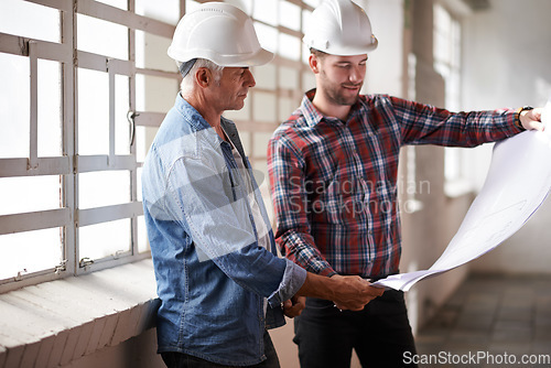Image of Architecture team, blueprint and engineer reading for planning, analysis or real estate development. Men, paper and design at property, construction site or building with helmet, discussion or vision