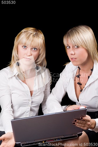 Image of Two businesswomen with laptop. Isolated on black background