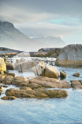 Image of Ocean, rocks and landscape with beach and outdoor, travel with summer vacation in South Africa. Environment, seaside location and tropical destination with journey to sea and nature with adventure