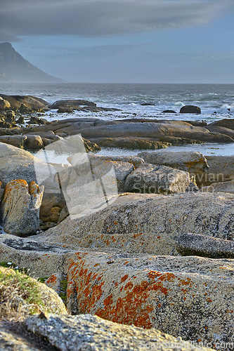 Image of Ocean, rocks and landscape with beach and waves, travel with summer vacation and outdoor. Environment, sea view and seaside location with tropical destination and journey with nature and adventure