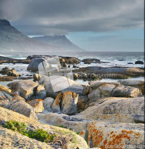 Image of Sea, rocks and landscape with beach and waves, travel with summer vacation and outdoor. Environment, ocean view and seaside location with tropical destination and journey with nature and adventure