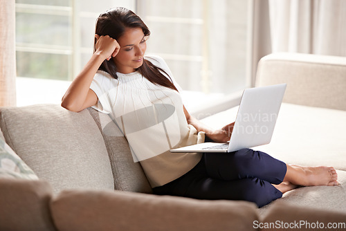 Image of Laptop, internet and a woman relax at home while streaming movies. Calm female person on lounge couch browsing and reading email, research or social media and online shopping with tech connection