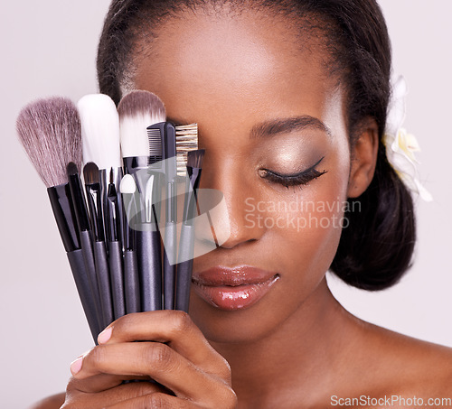 Image of Cosmetic tools, makeup and black woman with brushes, face on studio background with application tool. Skincare, beauty and cosmetics, facial skin care model with luxury contour tools and closed eyes.