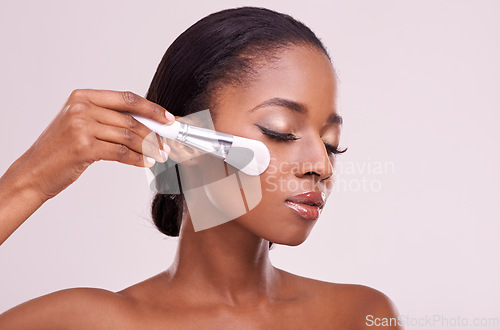 Image of Skincare, makeup and black woman with brush on face in studio mockup with cosmetic application tool. Beauty, blush and cosmetics, facial skin care model with luxury glow product on grey background.