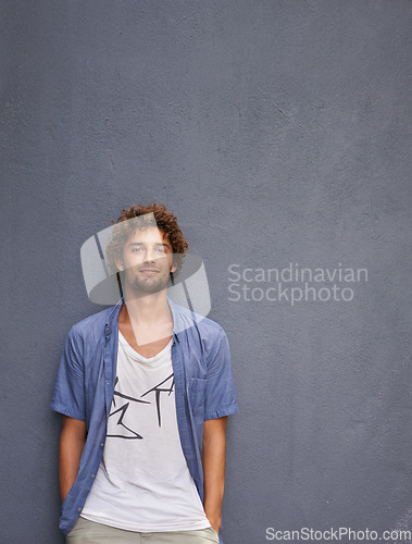 Image of Fashion, confidence and portrait of a man by a wall with mockup space with a casual, cool and stylish outfit. Happy, positive and handsome male model with trendy style by gray background with mock up