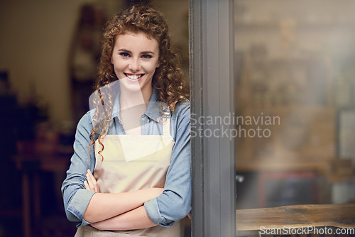 Image of Smile, arms crossed and portrait of woman at restaurant for small business, coffee shop or waiter. Entrepreneur, happy and space with female barista at front door of cafe for diner in food industry