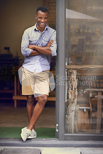 Image of Laughing, coffee shop and man as small business owner at front door with arms crossed. Black entrepreneur person as barista, manager or funny waiter in restaurant for service, thinking and goals