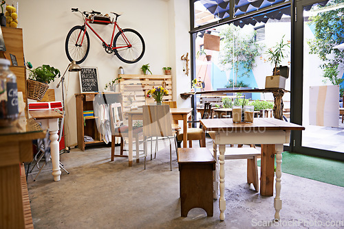 Image of Coffee shop, empty interior and space with table, chairs and furniture or small business, bistro and cafe with unique design and style. Background, creative startup and food store with bike on wall