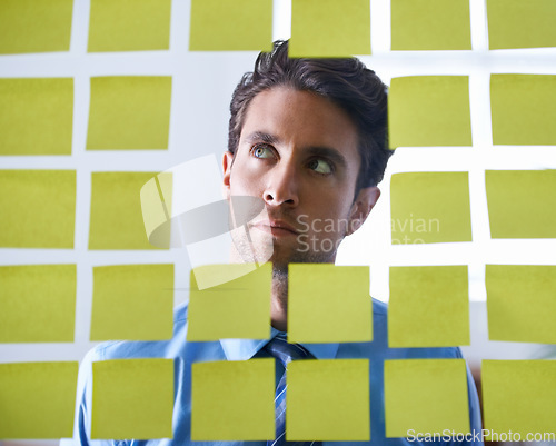Image of Businessman, face and thinking with sticky note for brainstorming, planning agenda and ideas on glass at office. Focus man contemplating business decision, strategy and problem solving for solution
