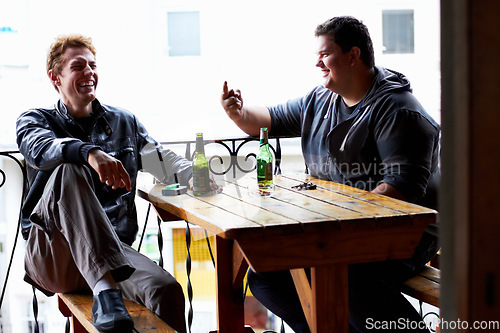 Image of Men, friends laugh and drinking beer at a pub and restaurant with conversation and discussion. Alcohol, guys and young people together at diner with alcohol and drink with bottle and joke at table