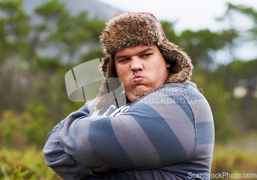 Image of Angry, frustrated and young overweight man in nature during winter unhappy, grumpy and sad due to outdoor problem. Anger, obesity and person with stress arms crossed and fail walking in a forest