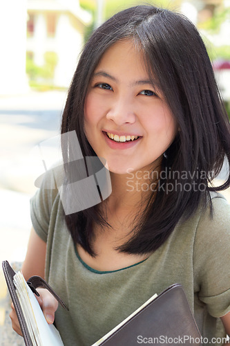 Image of Portrait, education and book with an asian woman student on university campus for learning or development. Study, smile or happy with a young female college pupil outdoor to study or learn in summer