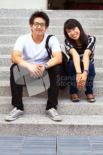 Image of Portrait, education and an asian couple on steps, sitting outdoor at university together for learning. Love, study or college with a man and woman student on stairs to relax while bonding at break