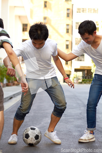 Image of Friends in road playing with soccer ball together for sports, fun and happy energy, urban games in Korea. Football game for teen friendship, group in Asian city street with weekend time in community.