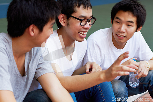 Image of Smile, talking and a group of asian friends sitting outdoor on university campus as scholarship students. Funny, conversation or bonding with happy young men outside together during college break