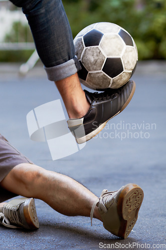 Image of Street soccer, fitness and legs of people with a ball for sports, training or cardio. Shoes, sport and feet of men playing football in the road for a workout, exercise or action together for a game