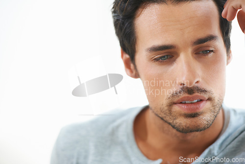 Image of Man, thinking and depressed with mental health or serious or sad and isolated on white background. Closeup, male person face contemplating and worried or in thought and feeling stress alone in studio